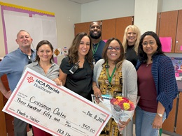  Cinnamon and the HCA administration, posing in front of a whiteboard in a class with a large check